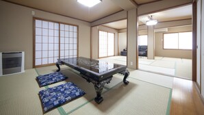 A traditional Japanese room with tatami flooring, a low table with cushions, and sliding doors. - Chouja Yashiki (Nanyo)