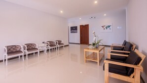A spacious lobby with a polished floor, a wooden coffee table, and seating areas with cushioned chairs. - Double S Hotel (Battambang)