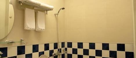 Un baño con salpicadero de azulejos a cuadros, un inodoro, un lavabo y un espejo.