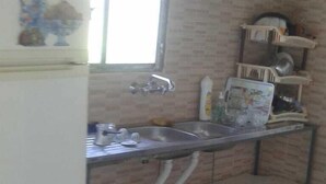 Una cocina compacta con refrigerador, pileta y ventana.