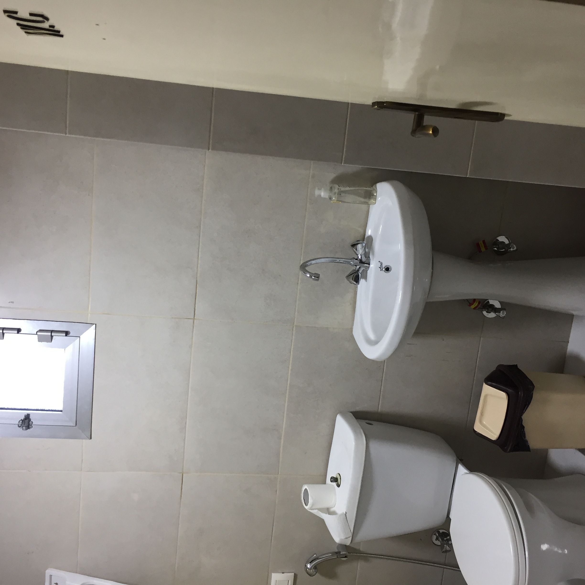 Un baño con lavabo, inodoro y espejo.