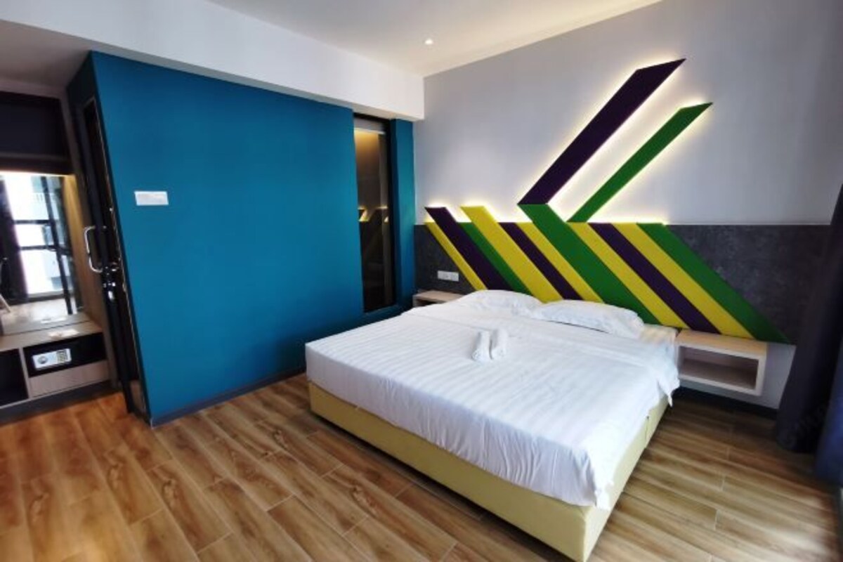A modern bedroom with a bed, a nightstand, and a wall-mounted light fixture.