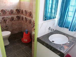 A bathroom with a toilet, shower, and sink. - Eden A Park (Palani)