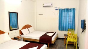 A hotel room with two single beds, a small table, a chair, an air conditioning unit, and a window with curtains. - Eden A Park (Palani)