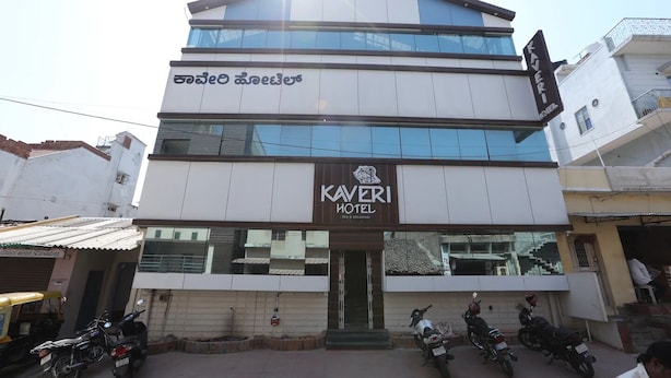A multi-story hotel with a sign reading "KAVERI HOTEL" and "RED & BREAKFAST". - Kaveri Hotel (Mysore)