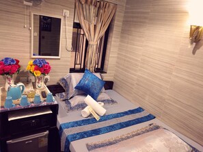 A neatly arranged bedroom with a bed, bedside table, and a mirror. - Hostel 16 (Kowloon)
