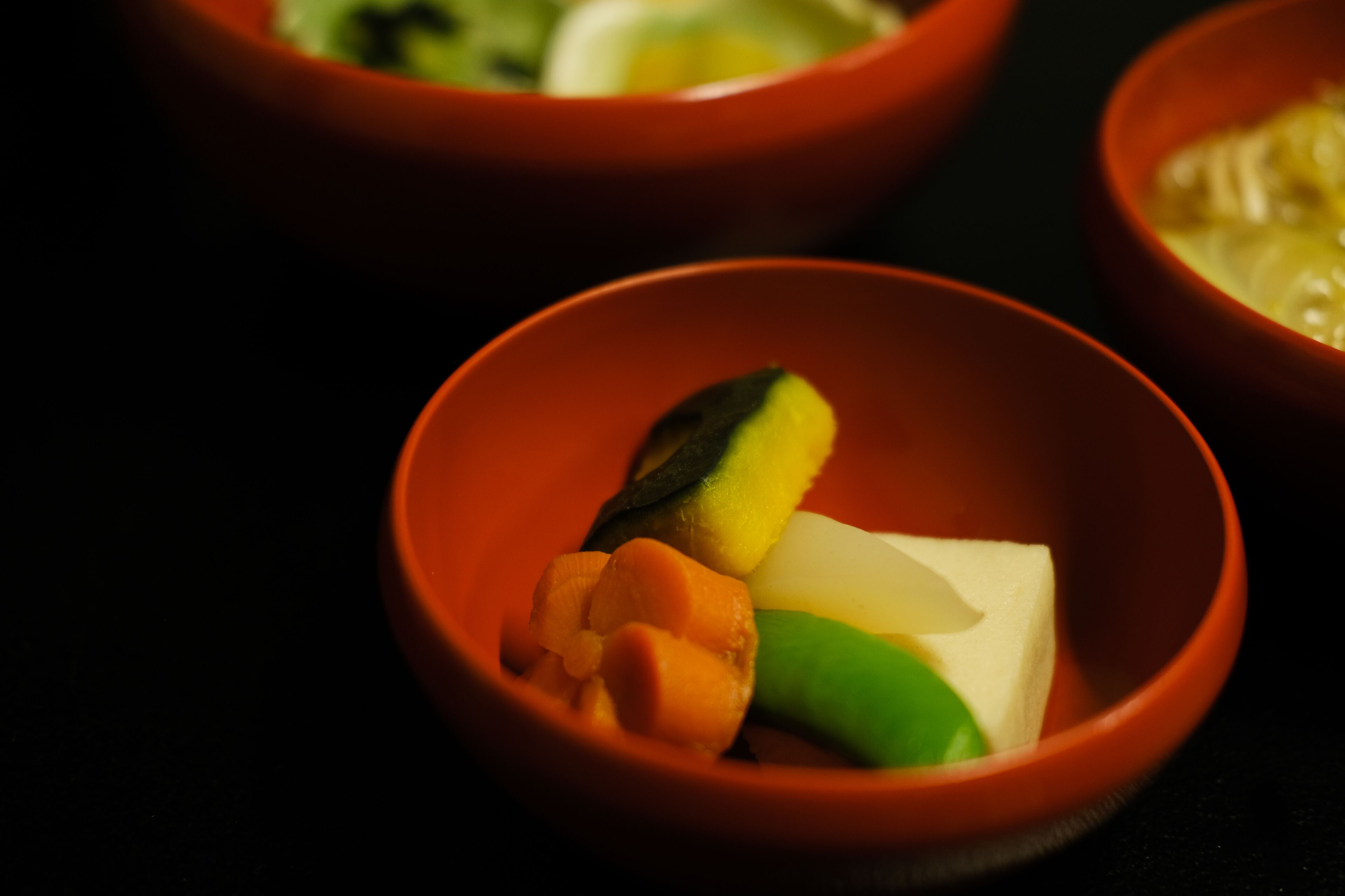 En närbild på en skål som innehåller olika sorters grönsaker och tofu.