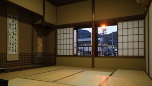 A traditional Japanese room with tatami flooring, sliding shoji doors, and a view of a mountain. - Zenkoji Temple Yakuoin (Nagano)