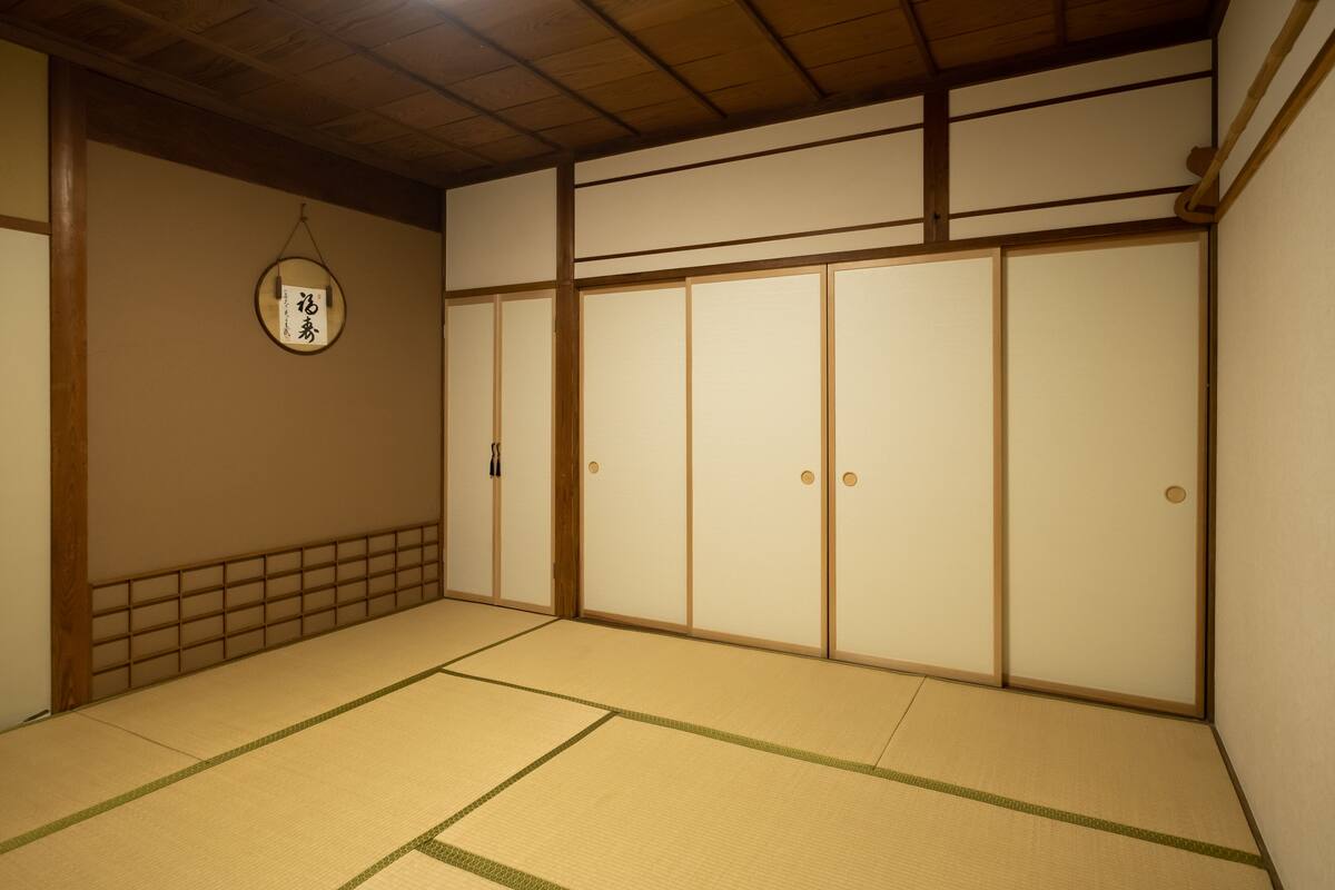 Ein traditioneller japanischer Raum mit Tatami-Böden, Schiebetüren und einem Shoji-Bildschirm.