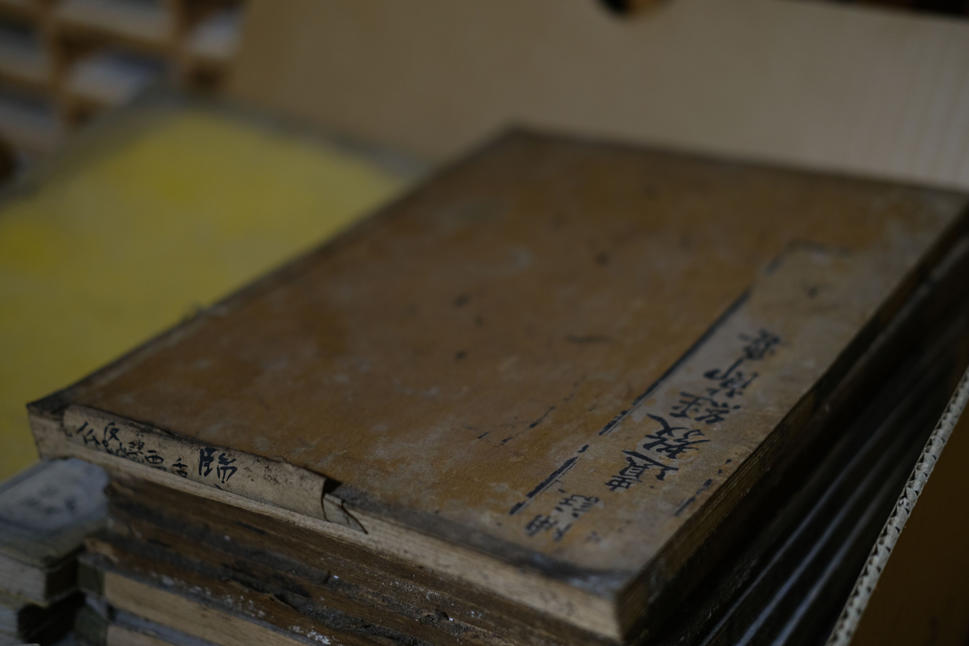 Ein Stapel alter Bücher mit handgeschriebenem Text auf dem Einband.