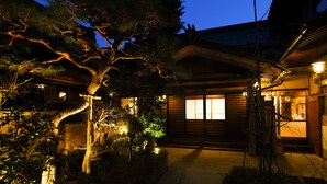 A traditional Japanese house with a wooden exterior, a visible entrance, and a lit window. - Zenkoji Temple Yakuoin (Nagano)