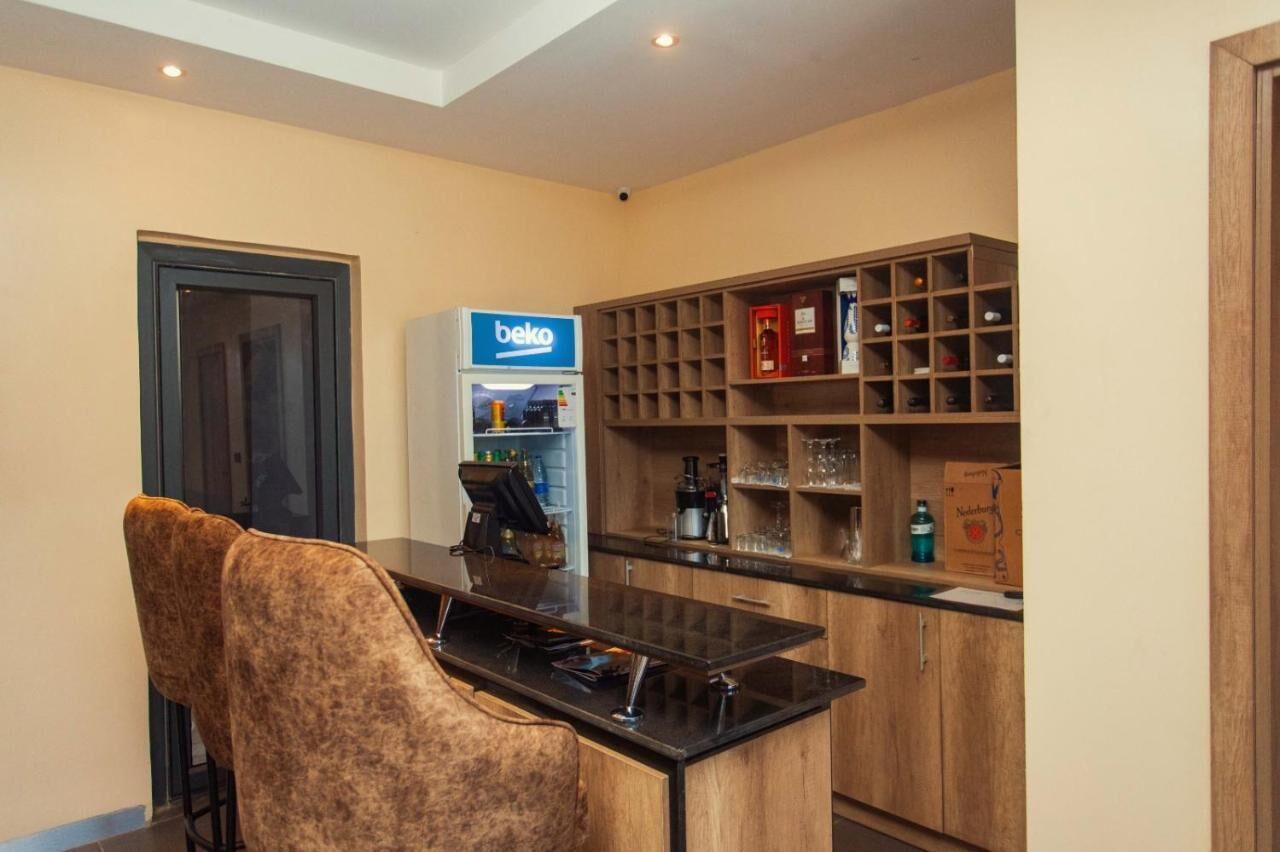 A modern kitchen with a built-in bar area, a coffee machine, and a wine rack.