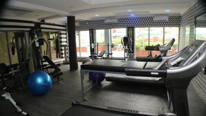 Une salle de sport équipée de tapis de course, de ballons d’exercice et d’appareils de musculation.