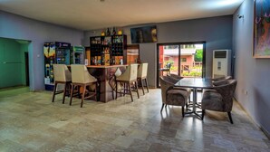 Un espace repas comprenant un bar, plusieurs options de sièges et une vue sur l’extérieur.