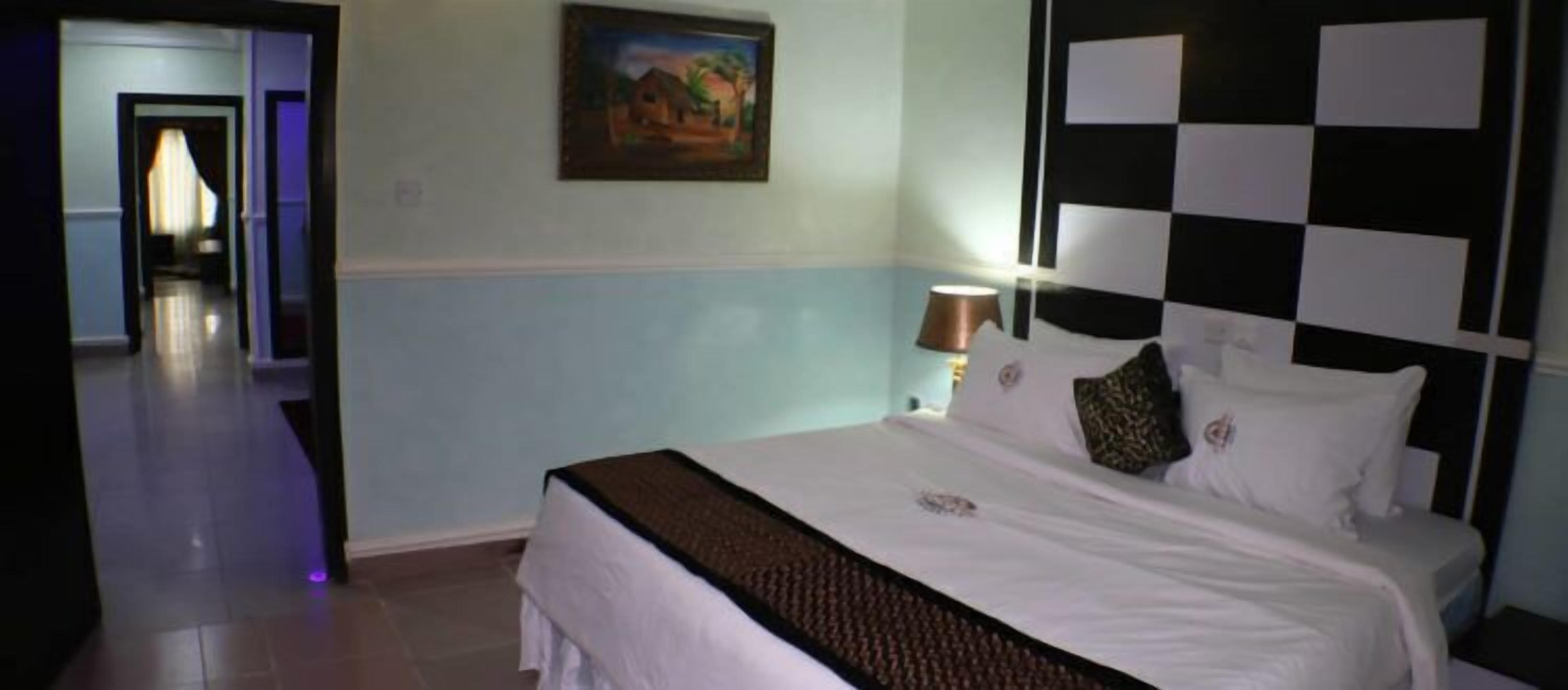 Une chambre d’hôtel avec un lit, une table de chevet, une lampe et un tableau au mur.