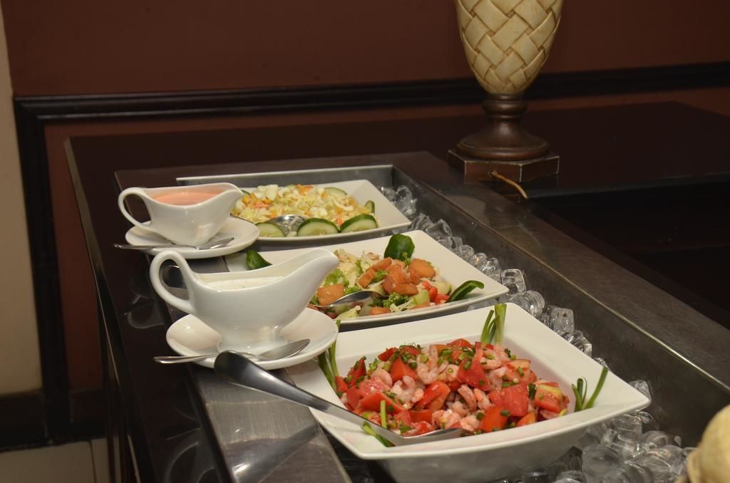 Ein Buffet mit verschiedenen Speisen, darunter ein Garnelensalat, ein Gemüsesalat und eine cremige Suppe.