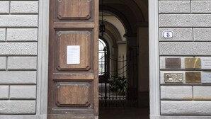 A large wooden door with a plaque, set in a stone building with a number plaque on the wall. - B&B Stupido Hotel (Florence)