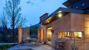 A modern building with a wooden deck, outdoor seating, and large windows. - Eco Villa Mt Beauty Near Falls Creek & Bright (Tawonga South)