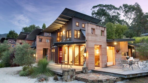 A modern two-story house with a deck, large windows, and a stone foundation. - Eco Villa Mt Beauty Near Falls Creek & Bright (Tawonga South)