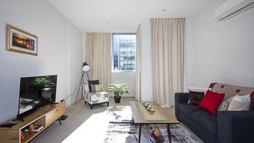 Apartment, 1 Bedroom, Pool Access, City View | Living area | Flat-screen TV