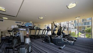 A gym with treadmills, elliptical machines, and a stationary bike.