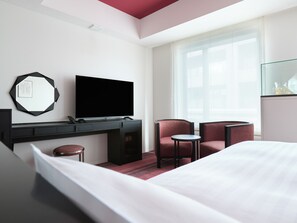 A hotel room with a bed, a desk with a flat-screen TV, two chairs, a small table, and a large window. - HOTEL GEOMETIQ Osaka Umeda, an Ascend Collection Hotel (Osaka)