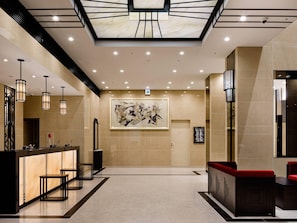 A lobby with a reception desk, seating area, and a large abstract painting on the wall. - HOTEL GEOMETIQ Osaka Umeda, an Ascend Collection Hotel (Osaka)