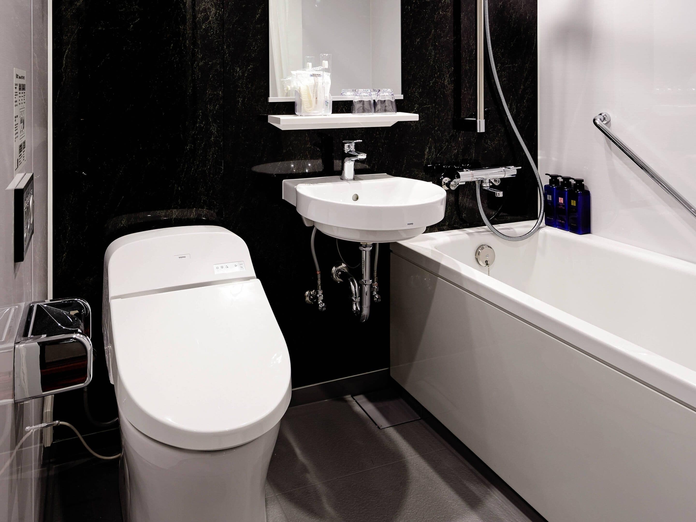 A modern bathroom with a toilet, sink, and bathtub.