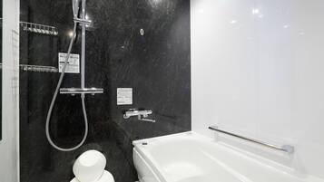 A modern bathroom with a bathtub, a shower, and a toilet.