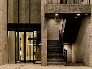 A building entrance with a glass door, a staircase, and a potted plant. - HOTEL GEOMETIQ Osaka Umeda, an Ascend Collection Hotel (Osaka)