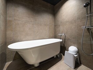 A modern bathroom with a freestanding bathtub, a handheld showerhead, and a toilet. - HOTEL GEOMETIQ Osaka Umeda, an Ascend Collection Hotel (Osaka)