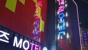 A motel with neon signage indicating "Motel" and "P" for parking.