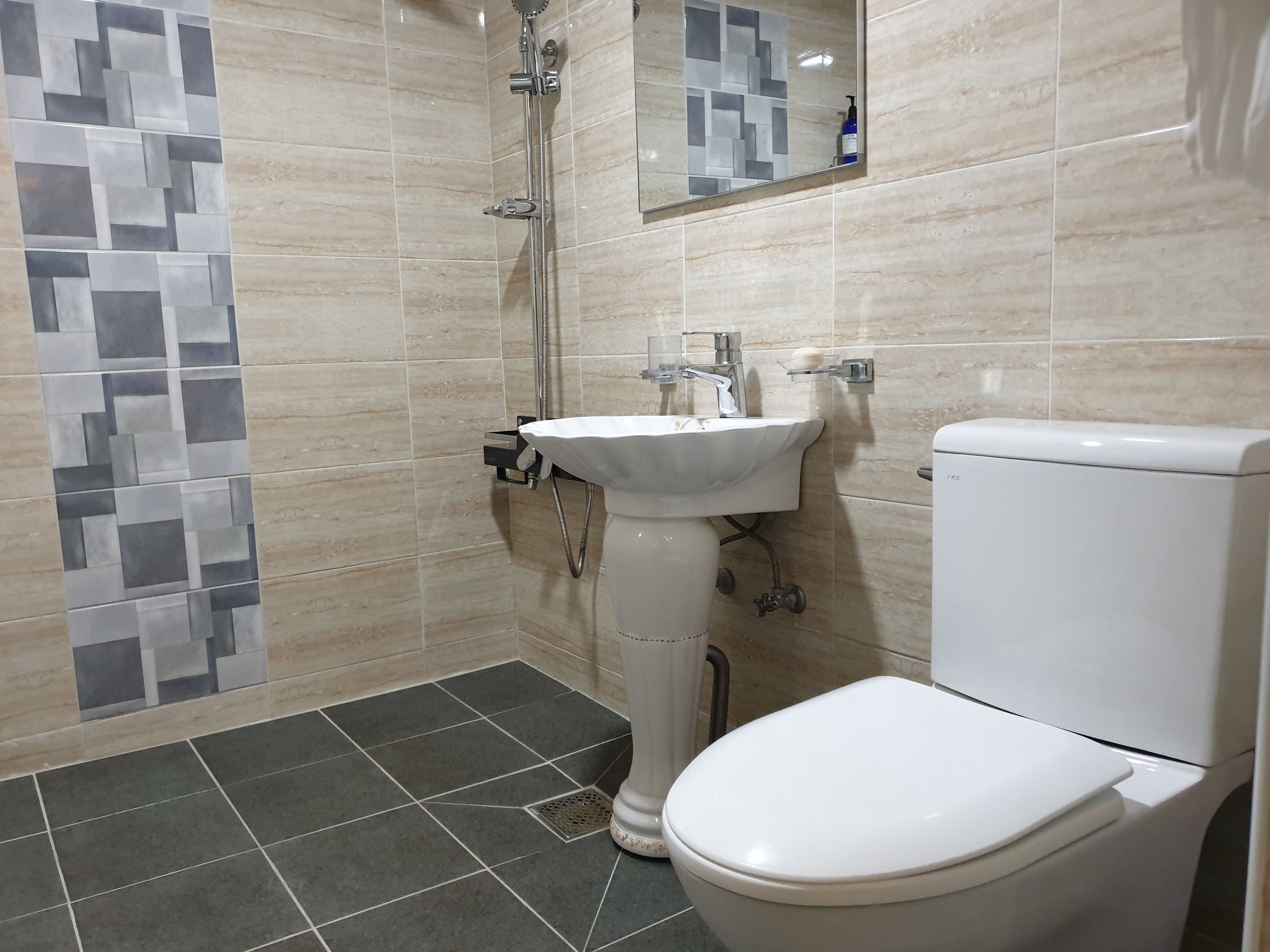 A bathroom with a toilet, sink, and shower.