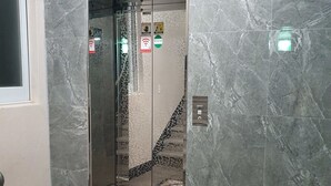An elevator with a digital display, a Wi-Fi symbol, and a handrail.