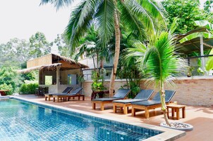 Una piscina al aire libre, tumbonas