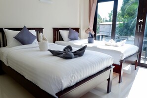 Habitación de hotel con dos camas, cada una con cabecero de madera, ropa de cama blanca y vistas a palmeras a través de amplias ventanas.