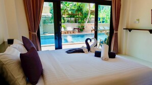 Une chambre d’hôtel avec un grand lit, une vue sur une piscine et une décoration représentant un cygne.