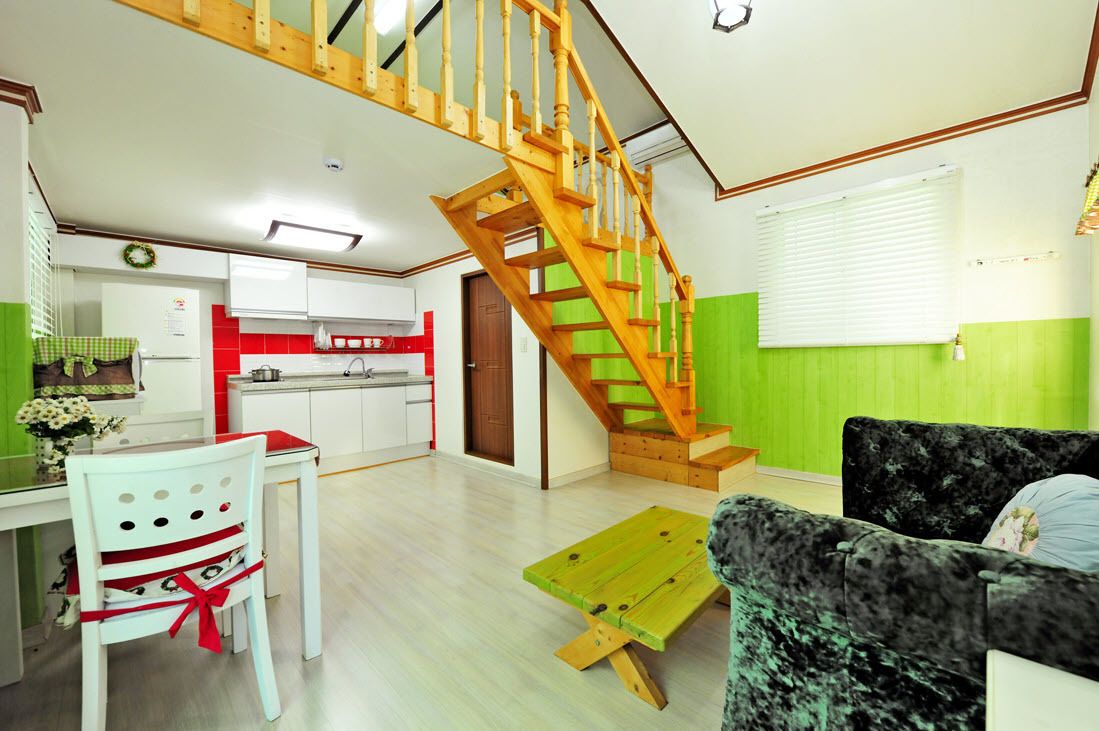 Un espace de vie compact comprenant une cuisine, un coin repas et un escalier.