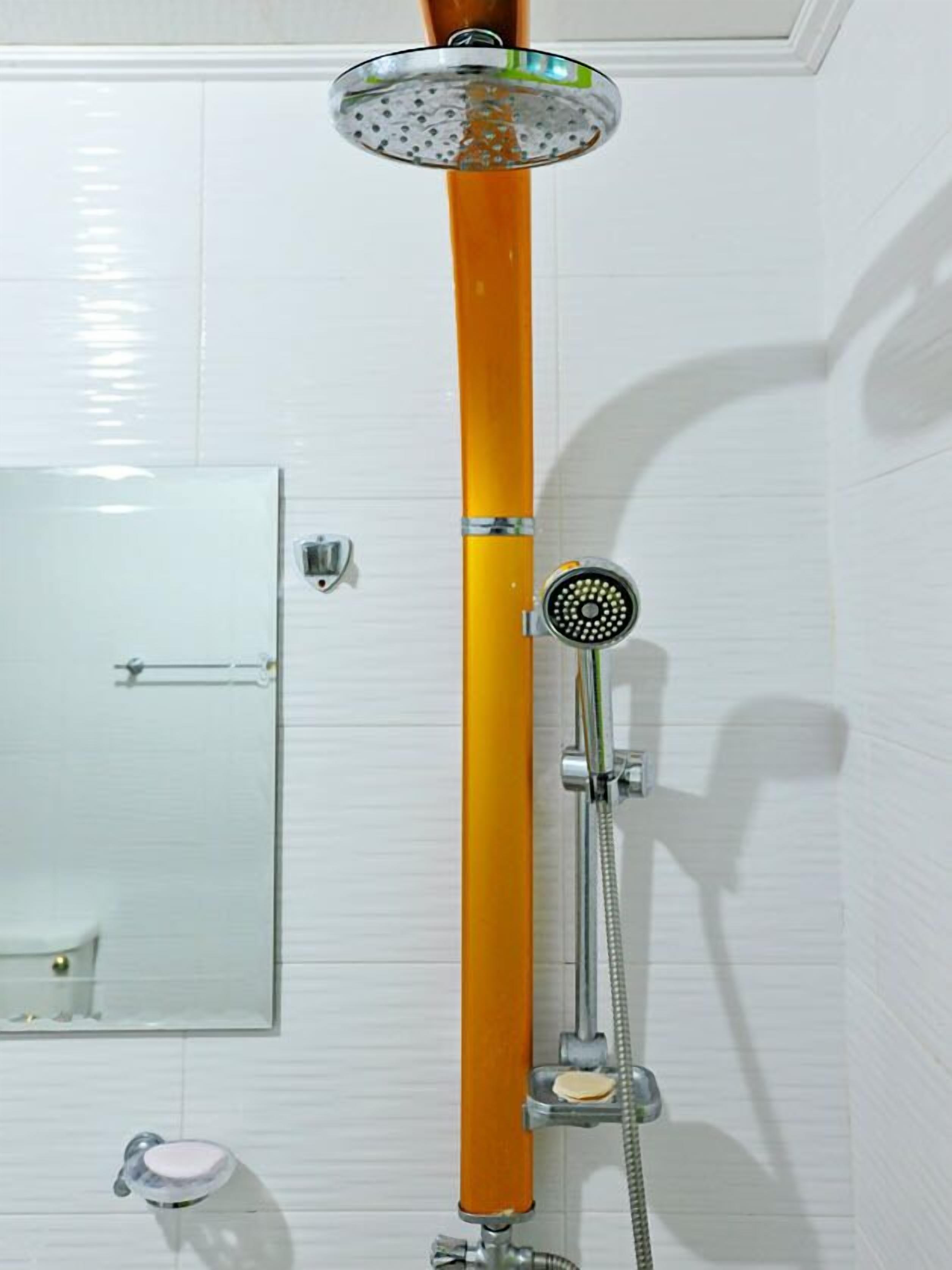 A shower with a wooden handle, a handheld showerhead, and a wall-mounted control panel.