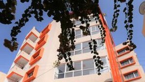 A multi-story building with a white facade and orange accents. - Hotel Atithi Bhawan by Sky Stays (Nathdwara)