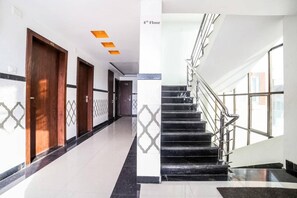 Un corridoio d'albergo con una scala che conduce al quarto piano.