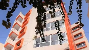 Um edifício com várias andares, varandas e janelas.