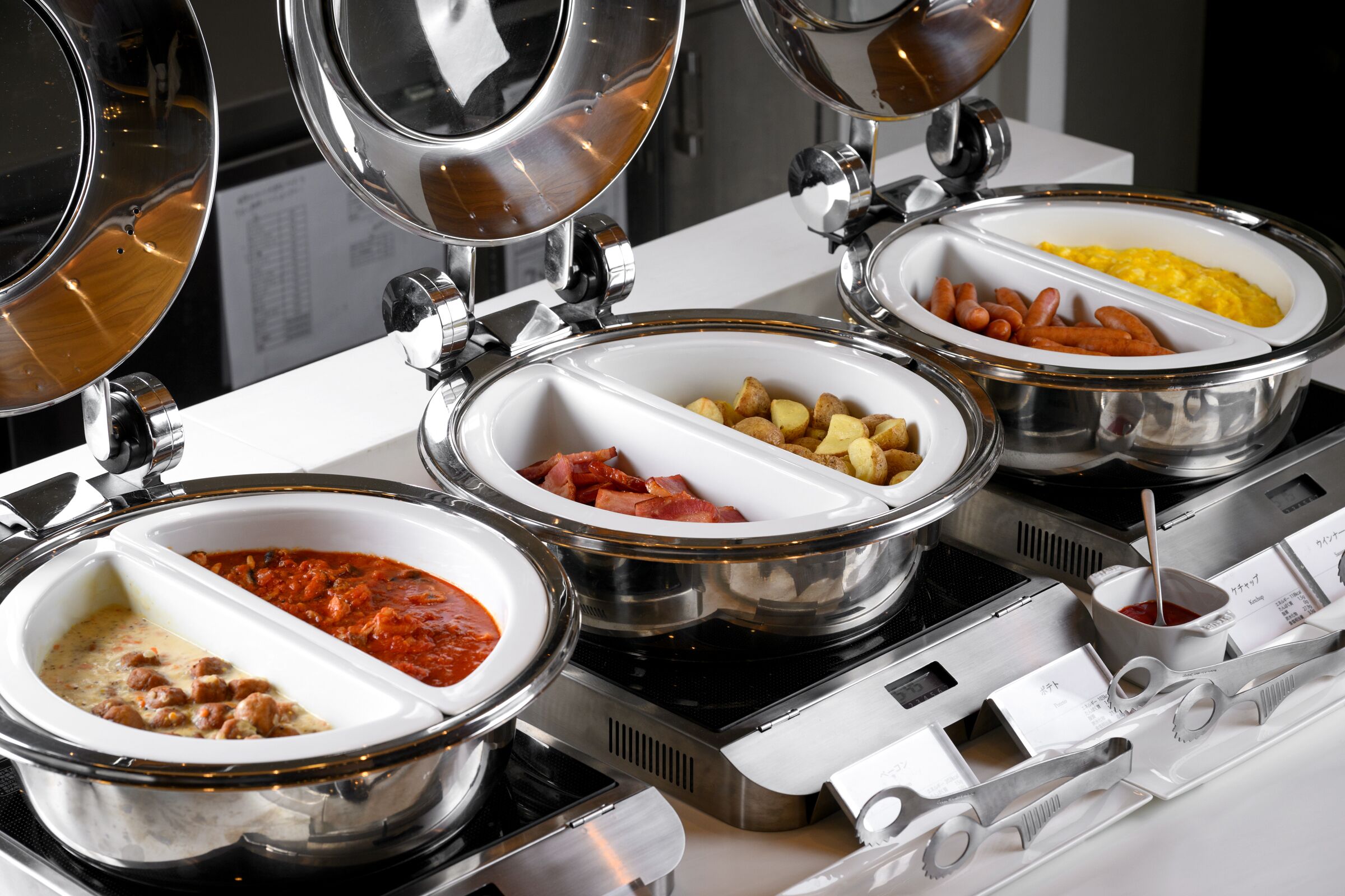 A buffet setup with various food items in separate bowls.