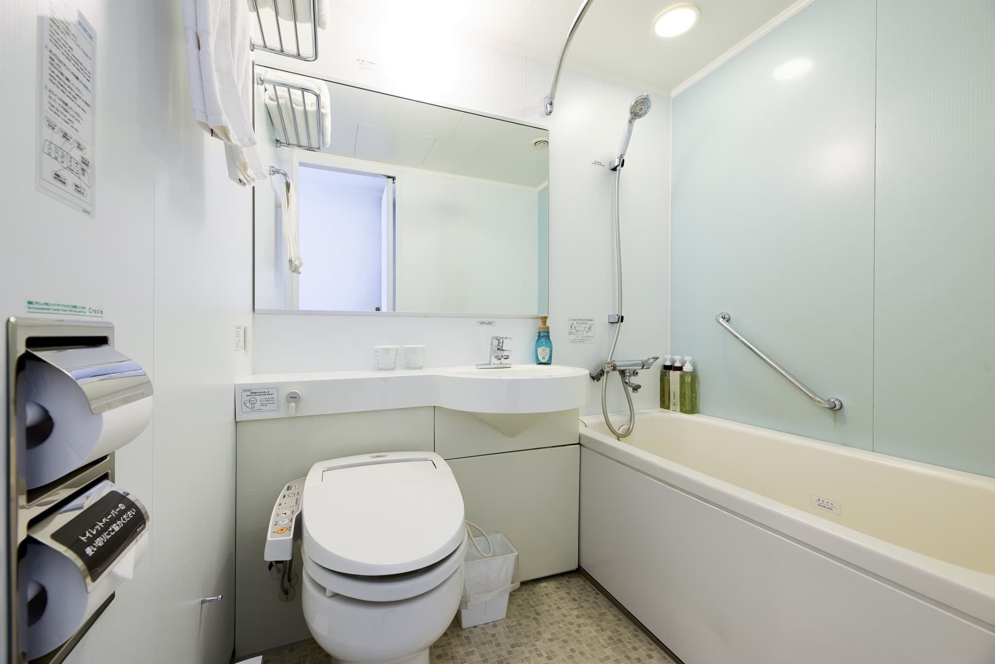 Un baño moderno con inodoro, lavamanos y bañera.