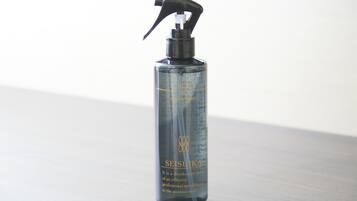 A clear bottle of Seisuka deodorant spray on a wooden surface.