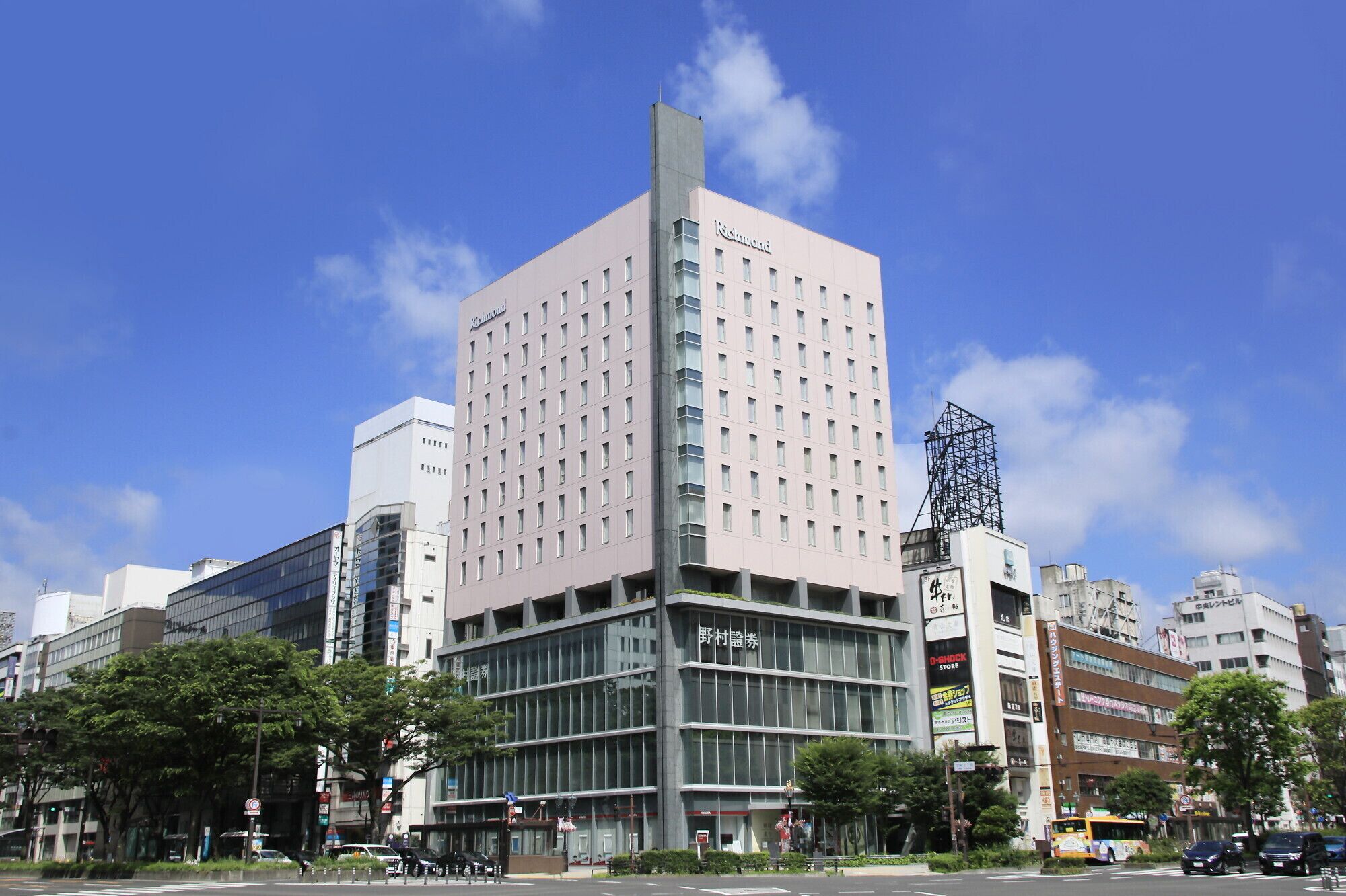 A modern building with a prominent pink facade and multiple windows.