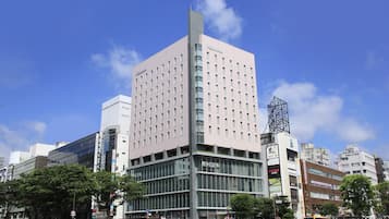 A modern building with a prominent pink facade and multiple windows.