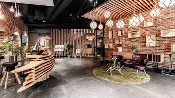 A modern interior with a reception desk, seating area, and decorative lighting.