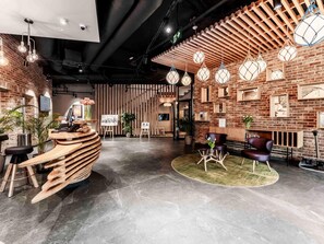A modern interior with a reception desk, seating area, and decorative lighting. - ibis Styles Lublin Stare Miasto (Lublin)