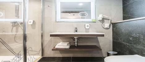 A modern bathroom with a glass shower enclosure, a vanity with a mirror, and a toilet.